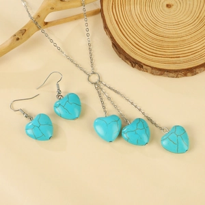 Detail view of boho silver necklace and heart turquoise earrings on natural wood decor