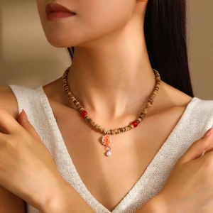 Ethnic wood bead necklace with red accents, pink rose pendant and white pearl charm