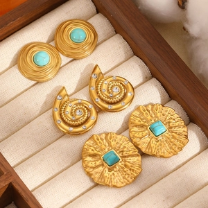 Detailed macro of vintage 18k gold plated hoop earrings with turquoise stones and textures