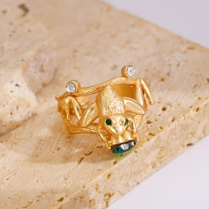 Macro detail of vintage frog ring holding a green heart gem with branch texture
