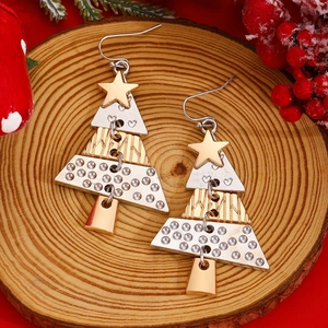 Detail of layered Christmas tree earrings with star and heart patterns on red background