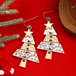 Detail of Christmas tree dangle earrings with gold and silver tiers on red festive background