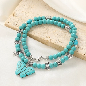 Detail of bohemian turquoise beaded necklace with silver butterfly charms and extension chain
