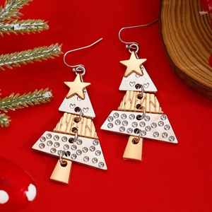Detailed view of layered alloy Christmas tree earrings on a festive red holiday background