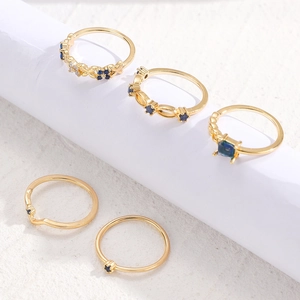 Detailansicht eines 5-teiligen vergoldeten Ring-Sets mit blauen Strasssteinen und Blumen
