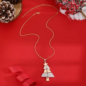 Festive gold Christmas tree necklace with star pendant on a vibrant red holiday background