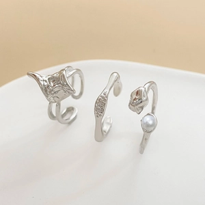 Detailansicht von drei minimalistischen Silberringen mit Perle im unregelmäßigen Design