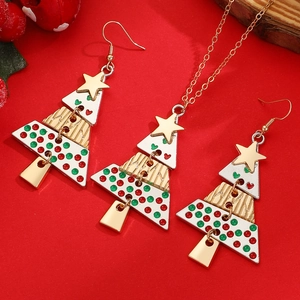 Macro detail of alloy Christmas tree jewelry set with colorful enamel on red background