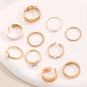 Draufsicht auf 10-teiliges goldfarbenes Ring-Set mit Perlen, Strass und weißer Emaille