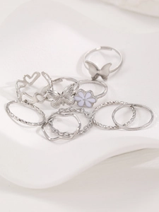 Detailaufnahme des 9-teiligen silbernen Ringsets mit Schmetterling und lila Blüten