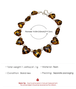 Detail view of heart-shaped resin beads and pearls necklace with size parameters