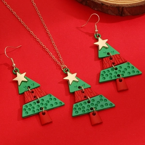 Detailed view of a Christmas tree jewelry set with green and red enamel and gold star detail