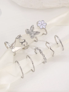 Detailliertes 9er-Set silberne Boho-Ringe mit Schmetterling und Herz auf weißer Seide