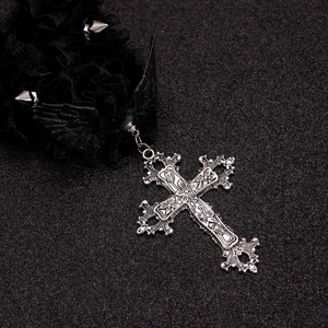 Dettaglio macro del choker gotico con pizzo nero, borchie e grande ciondolo a croce