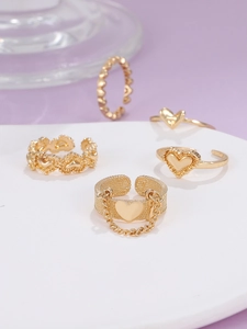 Detailansicht eines fünfteiligen Goldring-Sets mit Herzmotiven und Kettenverzierung