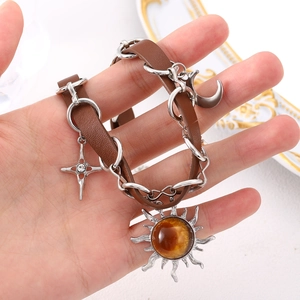 Close-up of bohemian leather bracelet featuring sun, moon and star pendants