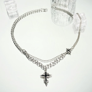 Close-up of layered silver hip hop bracelet featuring gothic cross and chunky curb chain