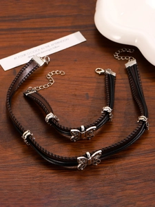Close-up of leather butterfly choker and bracelet set with silver metal details