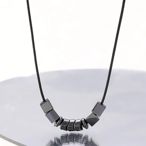 Detailed view of punk style choker with dark gray metallic beads on black cord