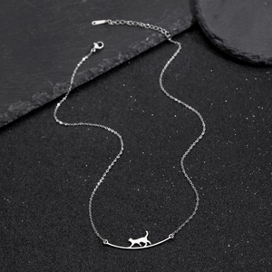Minimalistische Edelstahlkette mit silbernem Katzenanhänger auf schwarzem Grund