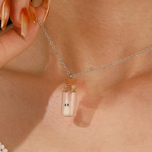 Nahaufnahme einer leuchtenden Halloween-Geisterkette mit einer kleinen Glasflasche