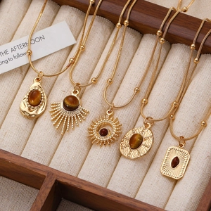 Detailed view of vintage gold necklaces with brown tiger eye stones in jewelry box