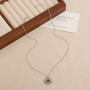 Detailed view of evil eye tiger eye pendant necklace on a wooden jewelry display stand