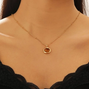 Close-up of golden Tiger Eye stone necklace on model with black lace collar