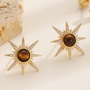 Detail of gold sunburst stud earrings with tiger eye stone and sparkling crystals