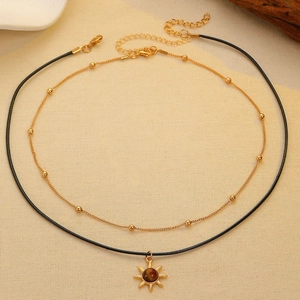 Detail of double-layer necklace set with golden bead chain and sun tiger eye pendant