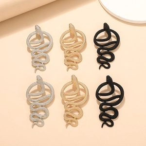 Detailed close-up of punk style snake earrings in gold, silver and black finishes