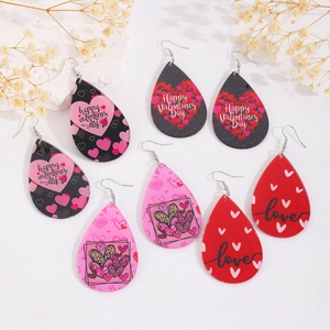 Close-up of teardrop earrings set with Happy Valentines Day patterns and floral decor