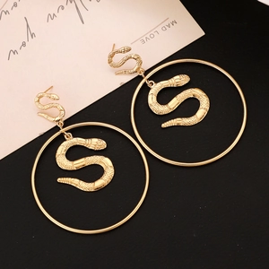 Detailed macro view of large gold snake hoop earrings with intricate scale texture
