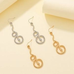 Detailed view of punk style snake earrings in gold and silver finish with scale texture