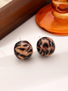 Close-up of stylish leopard print resin ball stud earrings with polished metal posts