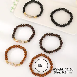 Detailed view of six-piece wood beaded bracelet set with cross pendant and evil eye charm