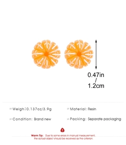 Detail showing 1.2cm orange resin earrings with floral shape and vibrant citrus design