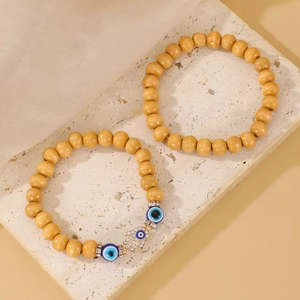 Detail of wooden beaded bracelets with Hamsa Hand and Evil Eye charms on stone
