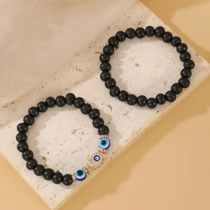 Detailed set of black beaded bracelets with evil eye bead and gold hamsa hand charm