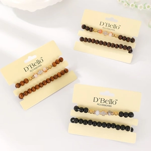 Three sets of wooden beaded bracelets with rhinestone cross and evil eye charms