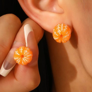 Realistic orange slice stud earrings made of resin shown on ear and fingertip