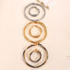 Detailed view of triple-strand metal coil necklace and bracelet set in multi-color finishes