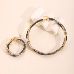 Detailed macro view of triple-strand mixed metal spring collar and bracelet jewelry set