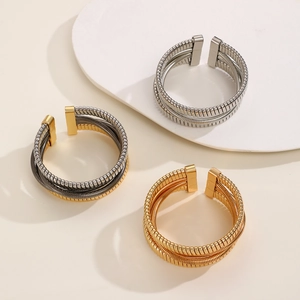 Detailed view of flexible metal woven cuffs in silver, gold, and tricolor finishes