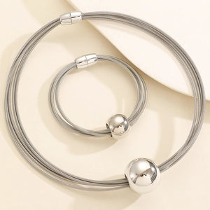 Close-up of silver multilayer wire necklace and bracelet with smooth metal sphere sliders