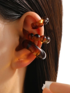 Macro shot of amber resin ear cuff set with three translucent pieces on the ear