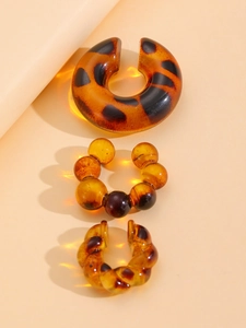 Macro detail of three-piece amber tortoiseshell resin ear cuff set with diverse textures