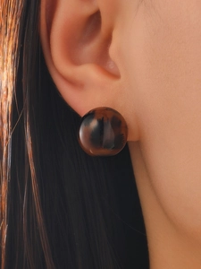 Close-up of a vintage tortoiseshell resin stud earring worn on a model's ear