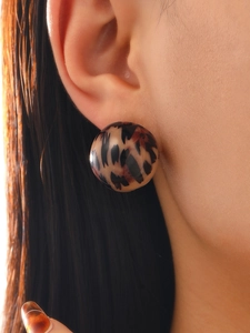 Detailed view of a vintage leopard print resin stud earring worn on a model's ear
