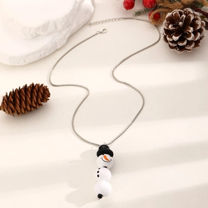 Detalle del collar con colgante de muñeco de nieve y cristales sobre fondo festivo invernal